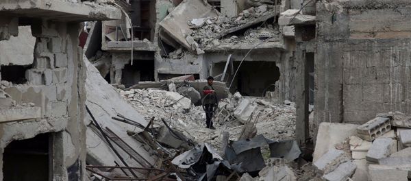 A man stands on rubble of damaged buildings in the besieged town of Douma, Eastern Ghouta, in Damascus, Syria March 30, 2018 - Sputnik International