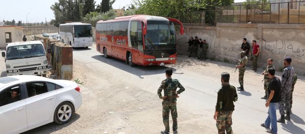 Pro-Syrian government forces gather around busses carrying Jaish al-Islam fighters and their families from their former rebel bastion of Douma as they arrive at the Syrian government-held side of the Wafideen checkpoint on the outskirts of Damascus, after being evacuated from the last rebel-held pocket in Estearn Ghouta on April 9, 2018 Pro-Syrian government forces gather around busses carrying Jaish al-Islam fighters and their families from their former rebel bastion of Douma as they arrive at the Syrian government-held side of the Wafideen checkpoint on the outskirts of Damascus, after being evacuated from the last rebel-held pocket in Estearn Ghouta on April 9, 2018 - Sputnik International