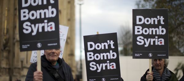 Supporters of the Stop the War Coalition hold placards protesting against Britain launching airstrikes against Islamic State extremists inside Syria, outside the Houses of Parliament as a debate goes on before a vote, Wednesday, Dec. 2, 2015. Supporters of the Stop the War Coalition hold placards protesting against Britain launching airstrikes against Islamic State extremists inside Syria, outside the Houses of Parliament as a debate goes on before a vote, Wednesday, Dec. 2, 2015. - Sputnik International