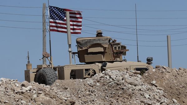 A U.S. soldier sits on an armored vehicle behind a sand barrier at a newly installed position near the tense front line between the U.S-backed Syrian Manbij Military Council and the Turkish-backed fighters, in Manbij, north Syria, Wednesday, April 4, 2018 A U.S. soldier sits on an armored vehicle behind a sand barrier at a newly installed position near the tense front line between the U.S-backed Syrian Manbij Military Council and the Turkish-backed fighters, in Manbij, north Syria, Wednesday, April 4, 2018 - Sputnik International