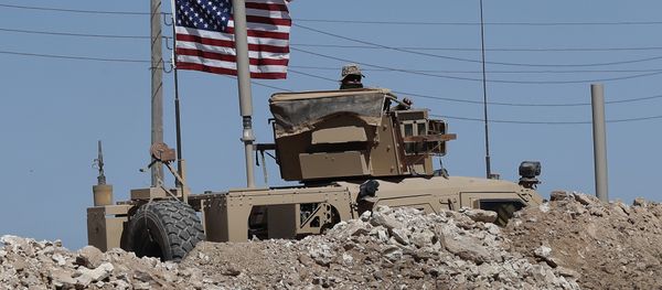 A U.S. soldier sits on an armored vehicle behind a sand barrier at a newly installed position near the tense front line between the U.S-backed Syrian Manbij Military Council and the Turkish-backed fighters, in Manbij, north Syria, Wednesday, April 4, 2018 A U.S. soldier sits on an armored vehicle behind a sand barrier at a newly installed position near the tense front line between the U.S-backed Syrian Manbij Military Council and the Turkish-backed fighters, in Manbij, north Syria, Wednesday, April 4, 2018 - Sputnik International