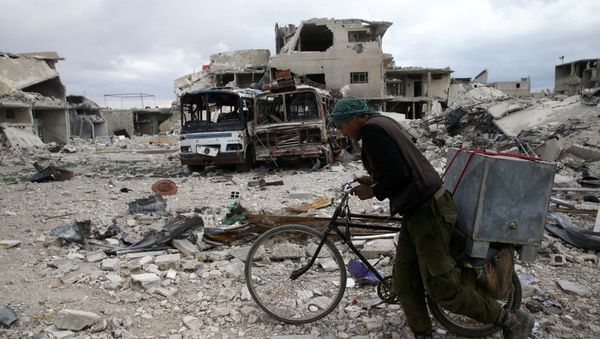 A man walks with his bicycle at a damaged site in the besieged town of Douma, Eastern Ghouta, in Damascus, Syria - Sputnik International