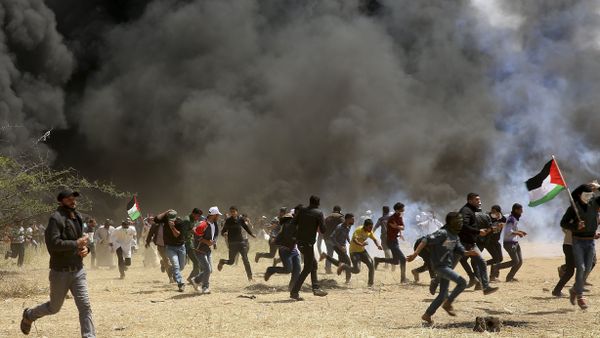 Palestinian protesters run to cover from teargas fired by Israeli soldiers during clashes with Israeli troops along Gaza's border with Israel, east of Khan Younis, Gaza Strip, Friday, April 6, 2018 Palestinian protesters run to cover from teargas fired by Israeli soldiers during clashes with Israeli troops along Gaza's border with Israel, east of Khan Younis, Gaza Strip, Friday, April 6, 2018 - Sputnik International