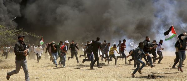 Palestinian protesters run to cover from teargas fired by Israeli soldiers during clashes with Israeli troops along Gaza's border with Israel, east of Khan Younis, Gaza Strip, Friday, April 6, 2018 - Sputnik International