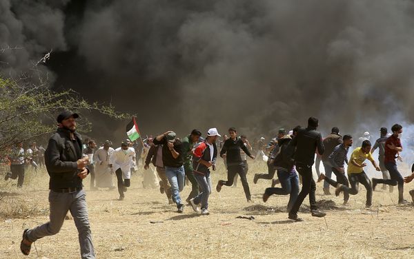 Palestinian protesters run to cover from teargas fired by Israeli soldiers during clashes with Israeli troops along Gaza's border with Israel, east of Khan Younis, Gaza Strip, Friday, April 6, 2018 Palestinian protesters run to cover from teargas fired by Israeli soldiers during clashes with Israeli troops along Gaza's border with Israel, east of Khan Younis, Gaza Strip, Friday, April 6, 2018 - Sputnik International