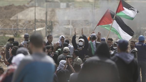Palestinian protesters chant slogans as they gather during a protest at the Gaza Strip's border with Israel, Friday, April 13, 2018 - Sputnik International