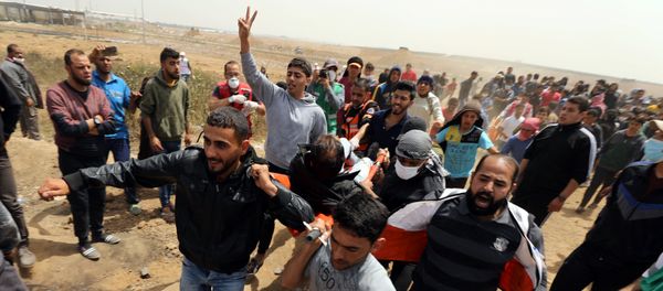 A wounded Palestinian is evacuated during clashes with Israeli troops at a protest demanding the right to return to their homeland, at the Israel-Gaza border, east of Gaza City, April 13, 2018 A wounded Palestinian is evacuated during clashes with Israeli troops at a protest demanding the right to return to their homeland, at the Israel-Gaza border, east of Gaza City, April 13, 2018 - Sputnik International