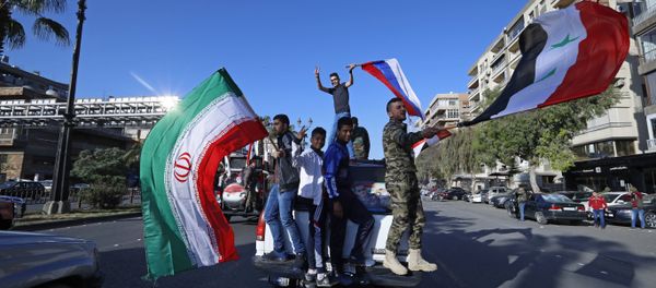 Syrian government supporters wave Syrian, Iranian and Russian flags as they chant slogans against U.S. President Trump during demonstrations following a wave of U.S., British and French military strikes to punish President Bashar Assad for suspected chemical attack against civilians, in Damascus, Syria, Saturday, April 14, 2018 Syrian government supporters wave Syrian, Iranian and Russian flags as they chant slogans against U.S. President Trump during demonstrations following a wave of U.S., British and French military strikes to punish President Bashar Assad for suspected chemical attack against civilians, in Damascus, Syria, Saturday, April 14, 2018 - Sputnik International