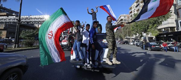 Syrian government supporters wave Syrian, Iranian and Russian flags as they chant slogans against US President Trump during demonstrations following a wave of US, British and French military strikes to punish President Bashar Assad for suspected chemical attack against civilians, in Damascus, Syria, Saturday, April 14, 2018. Syrian government supporters wave Syrian, Iranian and Russian flags as they chant slogans against US President Trump during demonstrations following a wave of US, British and French military strikes to punish President Bashar Assad for suspected chemical attack against civilians, in Damascus, Syria, Saturday, April 14, 2018. - Sputnik International