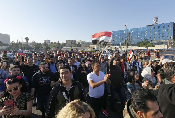 Syrians wave the national flag and wave portraits of President Bashar al-Assad as they gather at the Umayyad Square in Damascus on April 14, 2018, to condemn the strikes carried out by the United States, Britain and France against the Syrian regime Syrians wave the national flag and wave portraits of President Bashar al-Assad as they gather at the Umayyad Square in Damascus on April 14, 2018, to condemn the strikes carried out by the United States, Britain and France against the Syrian regime - Sputnik International