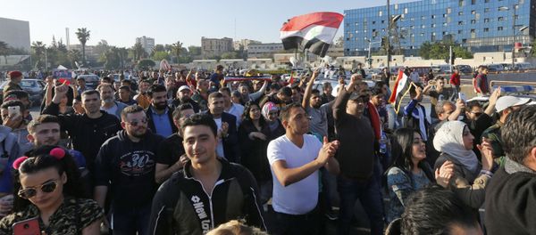 Syrians wave the national flag and wave portraits of President Bashar al-Assad as they gather at the Umayyad Square in Damascus on April 14, 2018, to condemn the strikes carried out by the United States, Britain and France against the Syrian regime Syrians wave the national flag and wave portraits of President Bashar al-Assad as they gather at the Umayyad Square in Damascus on April 14, 2018, to condemn the strikes carried out by the United States, Britain and France against the Syrian regime - Sputnik International