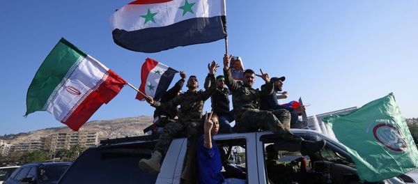 Syrian government supporters wave Syrian, Iranian and Russian flags as they chant slogans against U.S. President Trump during demonstrations following a wave of U.S., British and French military strikes to punish President Bashar Assad for suspected chemical attack against civilians, in Damascus, Syria, Saturday, April 14, 2018 - Sputnik International