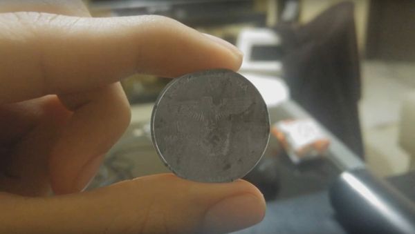 A video has emerged on YouTube to show what looked like a coin with the Reichsadler Nazi Party symbol and the words Nueva Alemania or New Germany - Sputnik International