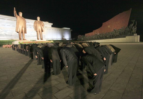 North Koreans bow in front of the statues of late leaders Kim Il Sung and Kim Jong Il on the Mansu Hill. - Sputnik International