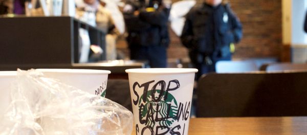 A Starbucks coffee cup with Stop Calling Cops! written on the side sits on a table as police monitor protestors demonstrating inside a Center City Starbucks, where two black men were arrested, in Philadelphia, Pennsylvania U.S., April 16, 2018. - Sputnik International