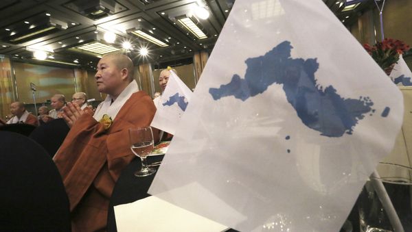 A woman Buddhist monk prays next to unification flags during the Peace Conference of World Buddhist Bhikkhunis for Reunification of North and South Korea in Seoul, South Korea, Thursday, April 12, 2018 A woman Buddhist monk prays next to unification flags during the Peace Conference of World Buddhist Bhikkhunis for Reunification of North and South Korea in Seoul, South Korea, Thursday, April 12, 2018 - Sputnik International
