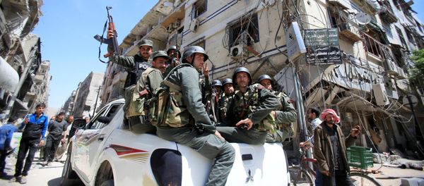 Members of the Syrian police hold their weapons as they sit on a back of a truck at the city of Douma, Damascus, Syria April 16, 2018 - Sputnik International