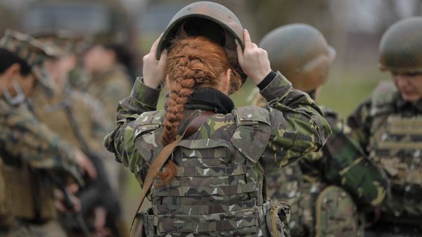 A Romanian female soldier adjusts her helmet before taking part in weapons training with US Marines female counterparts at the Capu Midia Surface to Air Firing Range, on the Black Sea coast in Romania, Monday, March 20, 2017 A Romanian female soldier adjusts her helmet before taking part in weapons training with US Marines female counterparts at the Capu Midia Surface to Air Firing Range, on the Black Sea coast in Romania, Monday, March 20, 2017 - Sputnik International