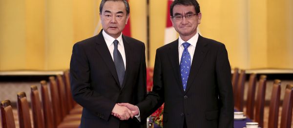 Japanese Foreign Minister Taro Kono, right, and his Chinese counterpart Wang Yi, left, shake hands ahead of their meeting in Tokyo Japanese Foreign Minister Taro Kono, right, and his Chinese counterpart Wang Yi, left, shake hands ahead of their meeting in Tokyo - Sputnik International
