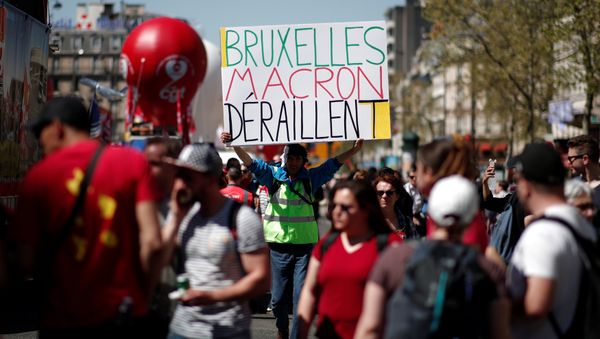 A man holds a placard reading Brussels Macron derailed during a demonstration against the French government's reform plans in Paris as part of a national day of protest, France, April 19, 2018 A man holds a placard reading Brussels Macron derailed during a demonstration against the French government's reform plans in Paris as part of a national day of protest, France, April 19, 2018 - Sputnik International