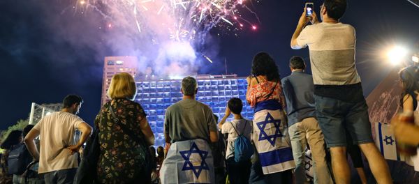 Israelis look at a fireworks set to begin the celebrations for Israel's 70th Independence Day, at Rabin square in Tel Aviv, Israel, Wednesday, April 18, 2018 Israelis look at a fireworks set to begin the celebrations for Israel's 70th Independence Day, at Rabin square in Tel Aviv, Israel, Wednesday, April 18, 2018 - Sputnik International