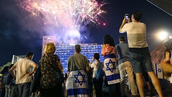 Israelis look at a fireworks set to begin the celebrations for Israel's 70th Independence Day, at Rabin square in Tel Aviv, Israel, Wednesday, April 18, 2018 Israelis look at a fireworks set to begin the celebrations for Israel's 70th Independence Day, at Rabin square in Tel Aviv, Israel, Wednesday, April 18, 2018 - Sputnik International