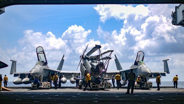 U.S. Navy sailors move aircraft from an elevator into the hangar bay of the aircraft carrier USS Theodore Roosevelt in the South China Sea April 8, 2018. Picture taken April 8, 2018 - Sputnik International