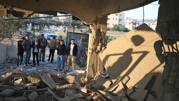 Palestinians check the house of a man suspected of murdering an Israeli rabbi in January 2018, after it was demolished by Israeli forces on April 24, 2018 in the West Bank city of Jenin - Sputnik International