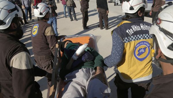 Syrian Civil Defence (known as the White Helmets) carry an injured man as Jaish al-Islam fighters and their families arrive from the former rebel bastion's main town of Douma at the Abu al-Zindeen checkpoint controlled by Turkish-backed rebel fighters near the northern Syrian town of al-Bab, on April 4, 2018 - Sputnik International