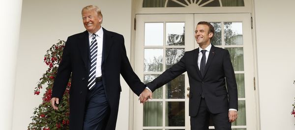 U.S. President Donald Trump and French President Emmanuel Macron hold hands as they walk down the West Wing colonnade past the Rose Garden at the White House in Washington, U.S., April 24, 2018 - Sputnik International