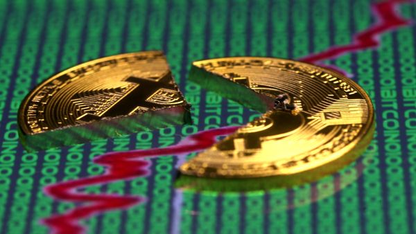 Broken representation of the Bitcoin virtual currency, placed on a monitor that displays stock graph and binary codes, are seen in this illustration picture, December 21, 2017 - Sputnik International