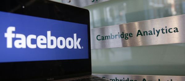 A laptop showing the Facebook logo is held alongside a Cambridge Analytica sign at the entrance to the building housing the offices of Cambridge Analytica, in central London on March 21, 2018 A laptop showing the Facebook logo is held alongside a Cambridge Analytica sign at the entrance to the building housing the offices of Cambridge Analytica, in central London on March 21, 2018 - Sputnik International