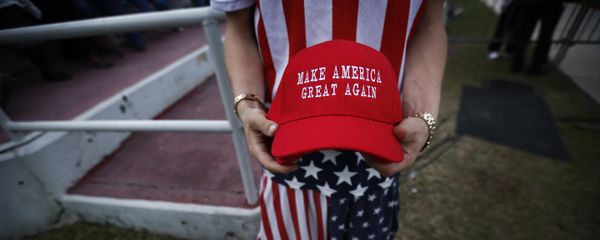 A man dressed in American flag clothes holds Make America Great Again hats. A man dressed in American flag clothes holds Make America Great Again hats. - Sputnik International