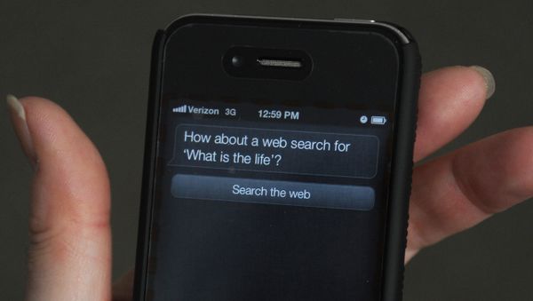 A woman tries to use Siri voice-activated assistant software built into the Apple iPhone 4S March 13, 2012 in Washington, DC. An iPhone 4S buyer has sued Apple for promising more than it delivered - Sputnik International
