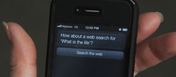A woman tries to use Siri voice-activated assistant software built into the Apple iPhone 4S March 13, 2012 in Washington, DC. An iPhone 4S buyer has sued Apple for promising more than it delivered - Sputnik International