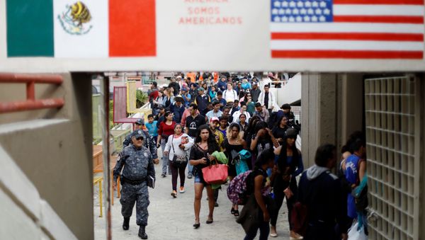 Members of a caravan of migrants from Central America walk towards the United States border and customs facility, where they are expected to apply for asylum, in Tijuana, Mexico April 29, 2018 Members of a caravan of migrants from Central America walk towards the United States border and customs facility, where they are expected to apply for asylum, in Tijuana, Mexico April 29, 2018 - Sputnik International