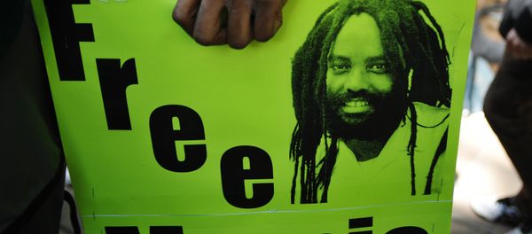 Protestors stand before an image of Mumia Abu-Jamal outside the US Department of Justice on April 24, 2012 in Washington, DC, calling for the release from prison of the ex-Black Panther militant, who was convicted for the killing of a white police officer in 1981 and sentenced to death. Protestors stand before an image of Mumia Abu-Jamal outside the US Department of Justice on April 24, 2012 in Washington, DC, calling for the release from prison of the ex-Black Panther militant, who was convicted for the killing of a white police officer in 1981 and sentenced to death. - Sputnik International