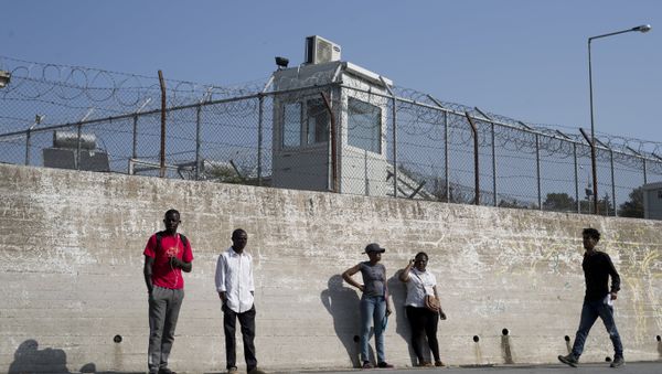 Migrants stand outside the walls of the Moria refugee camp on the northeastern Aegean island of Lesbos, Greece, Wednesday, May 2, 2018 - Sputnik International