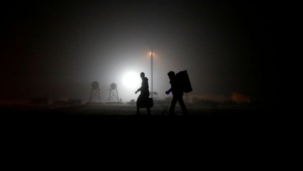 A group of migrants who said they were from Djibouti and Somalia walk along railway tracks after crossing the Canada-U.S. border in Emerson, Manitoba, Canada, March 27, 2017 - Sputnik International