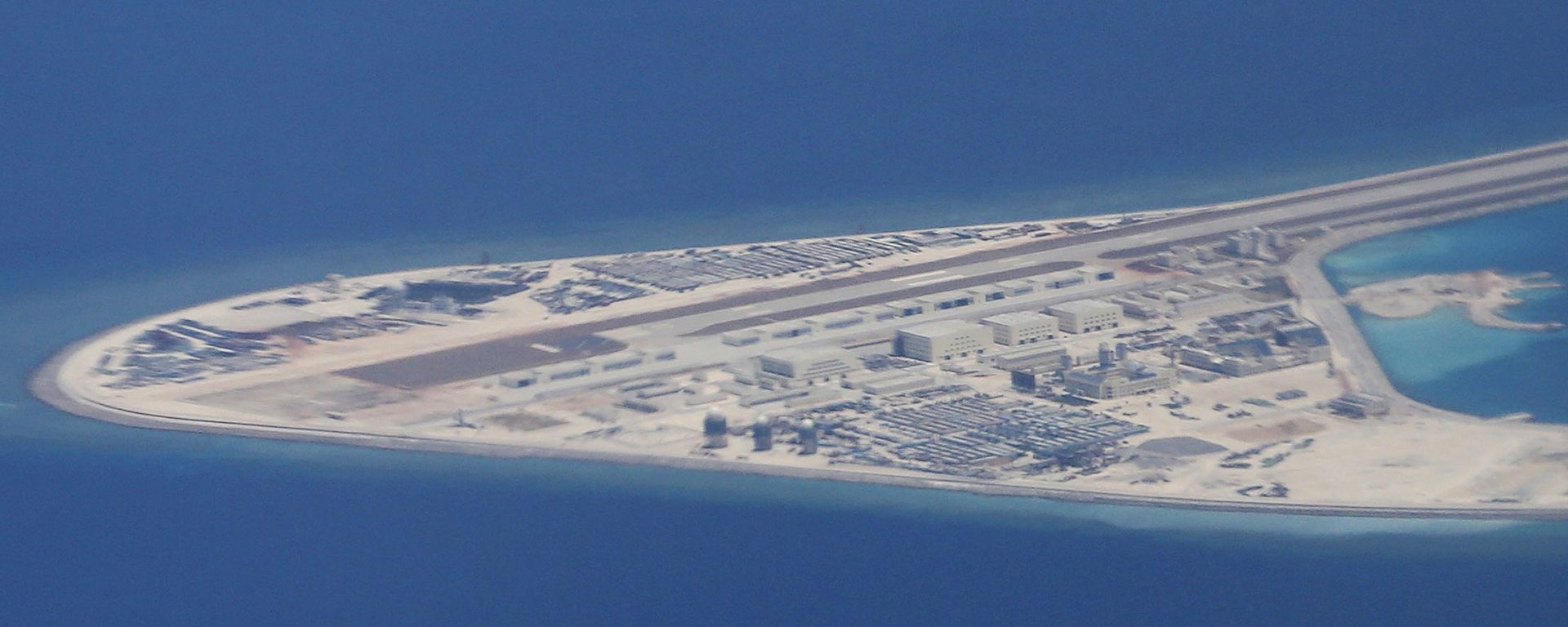 View from a Philippine Air Force C-130 transport plane, this photo captures Chinese structures and an airstrip on the man-made Subi Reef in the Spratly group of islands located in the South China Sea. The aerial photo was taken on Friday, April 21, 2017. View from a Philippine Air Force C-130 transport plane, this photo captures Chinese structures and an airstrip on the man-made Subi Reef in the Spratly group of islands located in the South China Sea. The aerial photo was taken on Friday, April 21, 2017. - Sputnik International, 1920, 25.12.2023