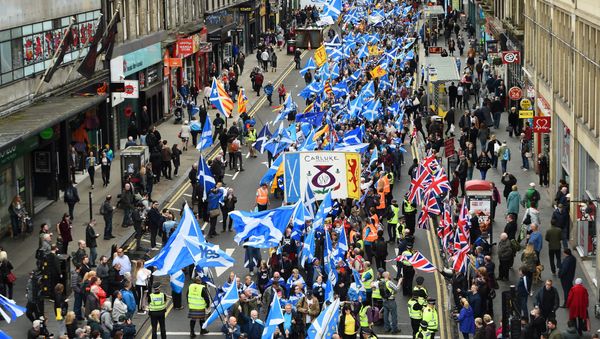 Anti-independence supporters wave Union Jack flags (R) as thousands of demonstrators carry Saltire flags, the national flag of Scotland, as they march in support of Scottish independence through the streets of Glasgow, on May 5, 2018 Anti-independence supporters wave Union Jack flags (R) as thousands of demonstrators carry Saltire flags, the national flag of Scotland, as they march in support of Scottish independence through the streets of Glasgow, on May 5, 2018 - Sputnik International