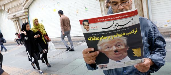 An Iranian man reads a copy of the daily newspaper 'Omid Javan' bearing a picture of US President Donald Trump with a headline that reads in Persian Crazy Trump and logical JCPOA (Joint Comprehensive Plan of Action), on October 14, 2017, in front of a kiosk in the capital Tehran - Sputnik International