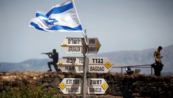 An Israeli soldier stands next to signs pointing out distances to different cities, on Mount Bental, an observation post in the Israeli-occupied Golan Heights that overlooks the Syrian side of the Quneitra crossing, Israel May 10, 2018 - Sputnik International