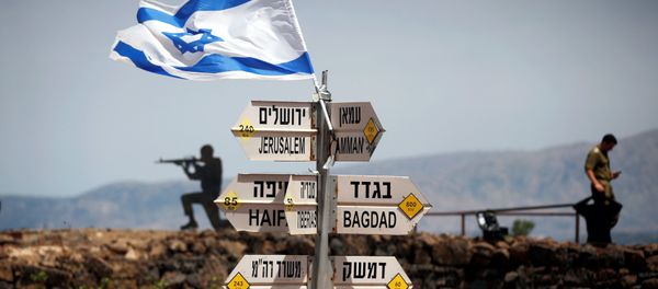 An Israeli soldier stands next to signs pointing out distances to different cities, on Mount Bental, an observation post in the Israeli-occupied Golan Heights that overlooks the Syrian side of the Quneitra crossing, Israel May 10, 2018 - Sputnik International