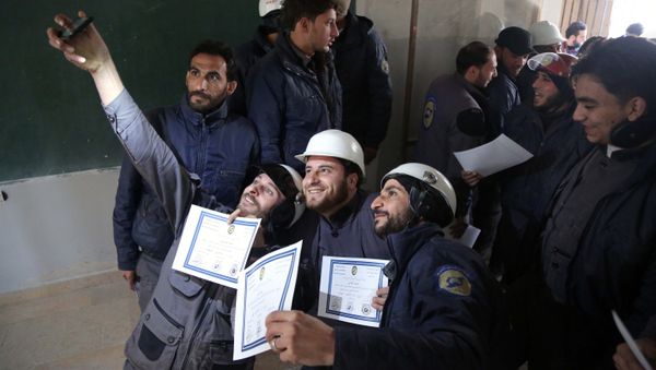 Members of the Syrian Civil Defence, known as the White Helmets, take a selfie with their certificates after taking part in a training session in the rebel-held eastern Ghouta area, east of the capital Damascus, on November 22, 2016 - Sputnik International