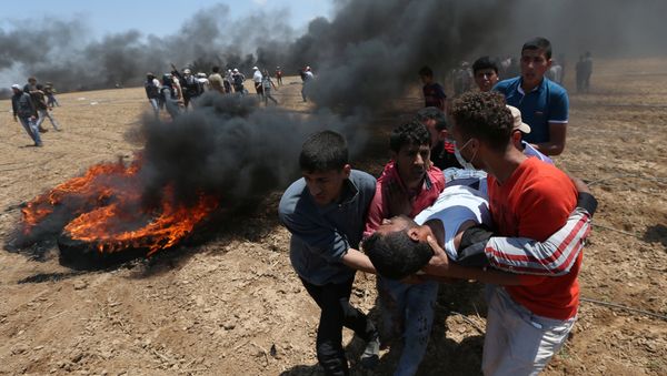 A wounded Palestinian demonstrator is evacuated during a protest against U.S. embassy move to Jerusalem and ahead of the 70th anniversary of Nakba, at the Israel-Gaza border in the southern Gaza Strip May 14, 2018 A wounded Palestinian demonstrator is evacuated during a protest against U.S. embassy move to Jerusalem and ahead of the 70th anniversary of Nakba, at the Israel-Gaza border in the southern Gaza Strip May 14, 2018 - Sputnik International