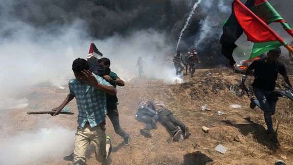 Palestinian demonstrators run for cover during a protest against U.S. embassy move to Jerusalem and ahead of the 70th anniversary of Nakba, at the Israel-Gaza border in the southern Gaza Strip May 14, 2018 - Sputnik International