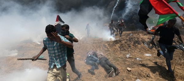 Palestinian demonstrators run for cover during a protest against U.S. embassy move to Jerusalem and ahead of the 70th anniversary of Nakba, at the Israel-Gaza border in the southern Gaza Strip May 14, 2018 Palestinian demonstrators run for cover during a protest against U.S. embassy move to Jerusalem and ahead of the 70th anniversary of Nakba, at the Israel-Gaza border in the southern Gaza Strip May 14, 2018 - Sputnik International