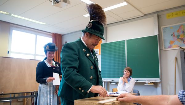 A man and a woman in traditional Bavarian dresses cast their ballots at a polling station in Unterwoessen near Rosenheim, southern Germany, during general elections on September 24, 2017 - Sputnik International