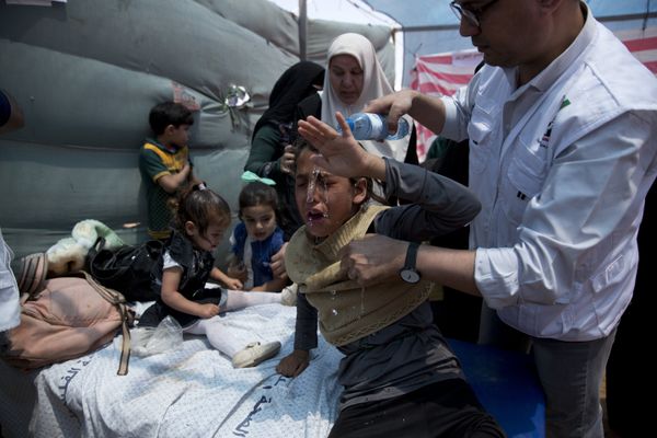 Medics treat Palestinian children suffering from teargas inhalation during a protest near Beit Lahiya, Gaza Strip, Monday, May 14, 2018 - Sputnik International